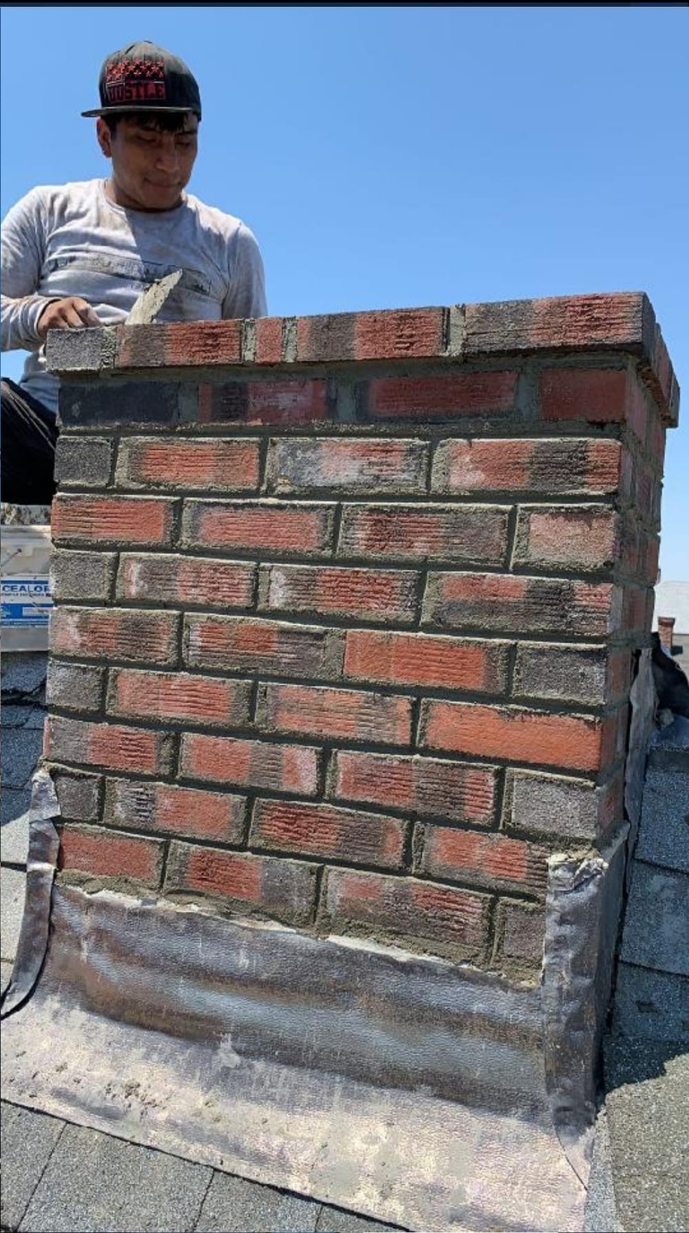 Manny De La Rosa, owner of De La Rosa Skylight & Chimney, working on a chimney